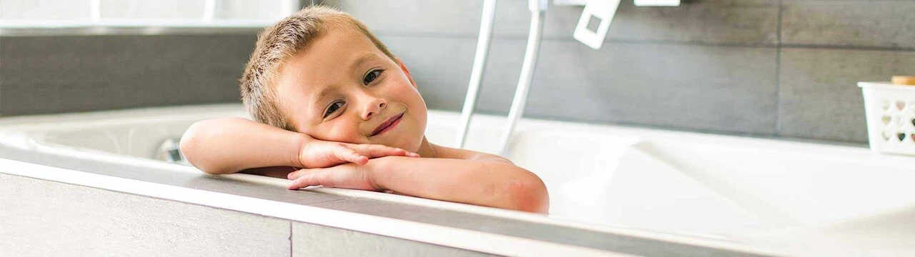 Junge hat Kopf auf Rand der Badewanne gelegt