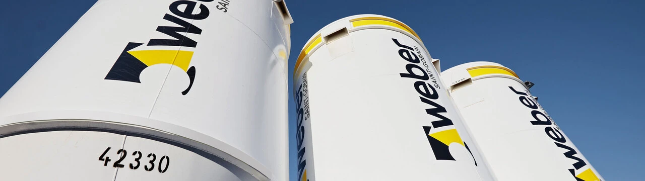 Drei Weber-Silos nebeneinander aufgereiht vor blauem Himmel