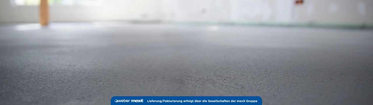 Eine Nahaufnahme eines Estrichs in einem weißen Raum, der Hintergrund ist stark verschwommen, der Fokus liegt auf der Textur in der Bildmitte