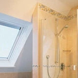 Aufnahme eines Badezimmers mit Dachfenster und Fliesendetails in der Dusche und verputzten Wänden