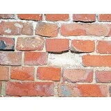 Alte, sanierungsbedürftige Klinkerfassade mit rotem Backstein