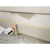 Sockel wird mit einer Fassadenbürste gestrichen