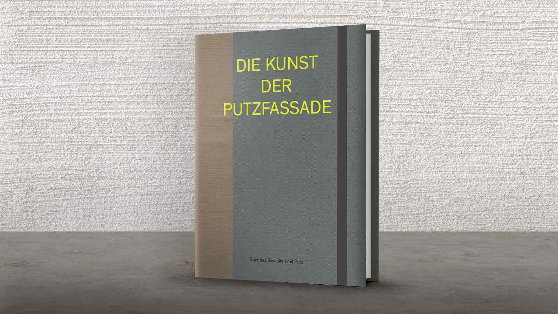 Die Kunst der Putzfassade Buch Das Buch "Die Kunst der Putzfassade" steht vor einer hellen Wand mit Kammzugputz