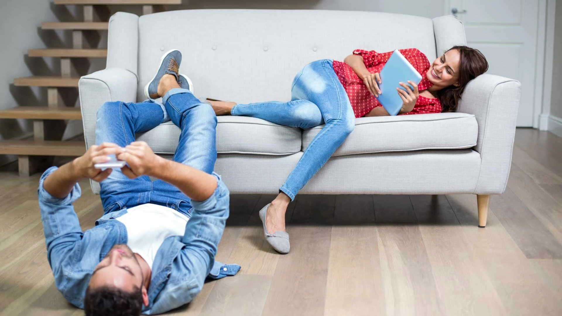 Pärchen liegt entspannt auf einer Couch in einem ausgebauten Keller