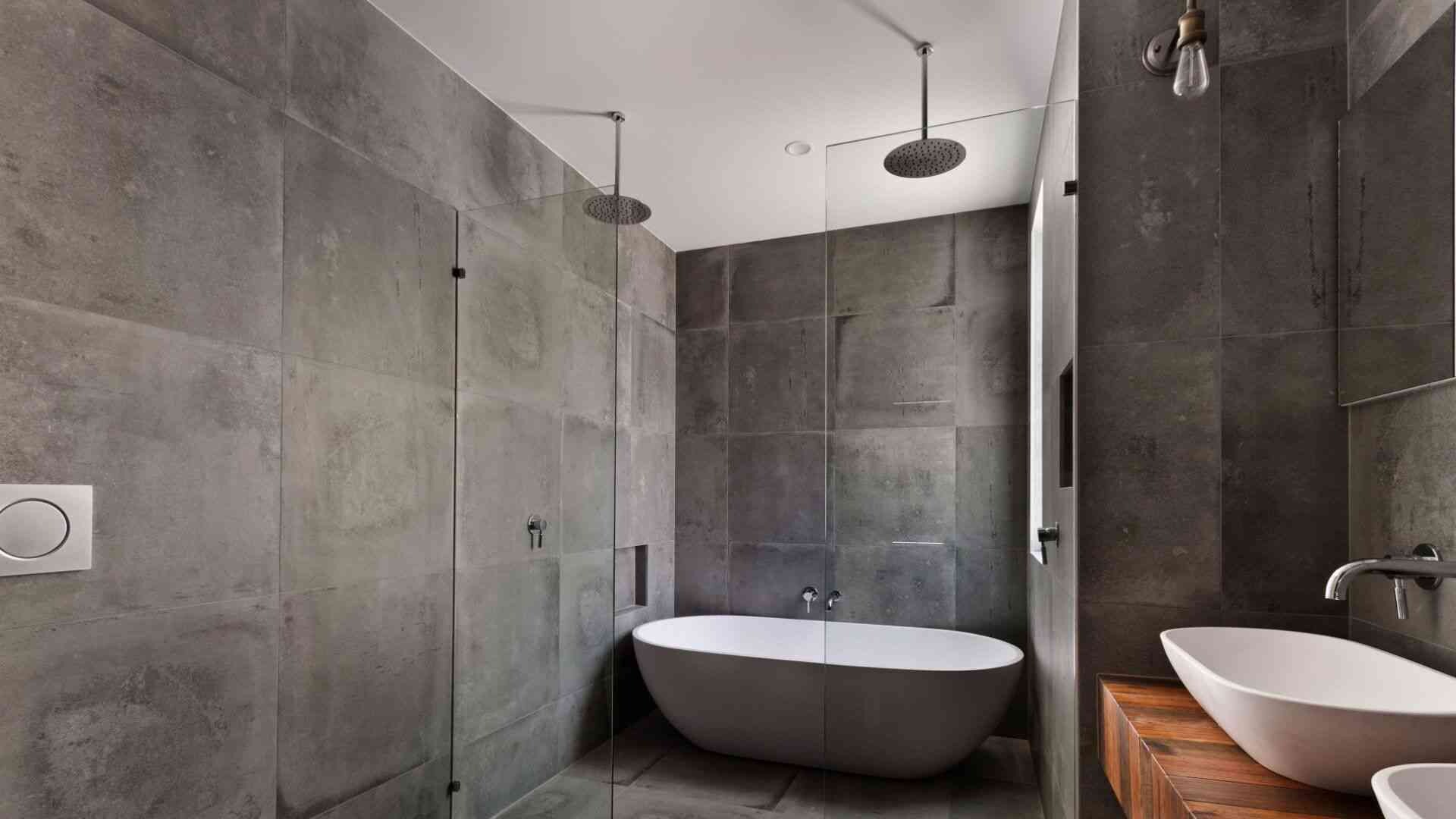 Badezimmer Sicht in ein modernes Badezimmer mit grauen Fliesen an den Wänden und einer Regendusche