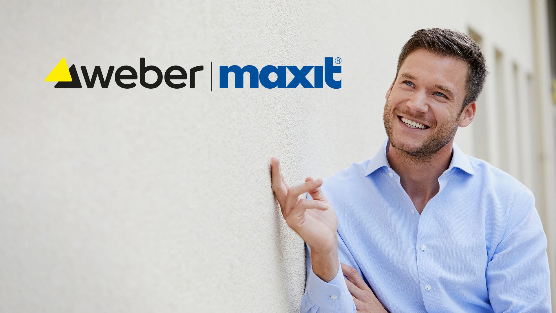 ein junger mann in blauem hemd lehnt mit seiner rechten schulter an einer weißen putzfassade, sein rechter zeigefinger berührt die fassade und er lächelt, links oben steht das weber maxit logo