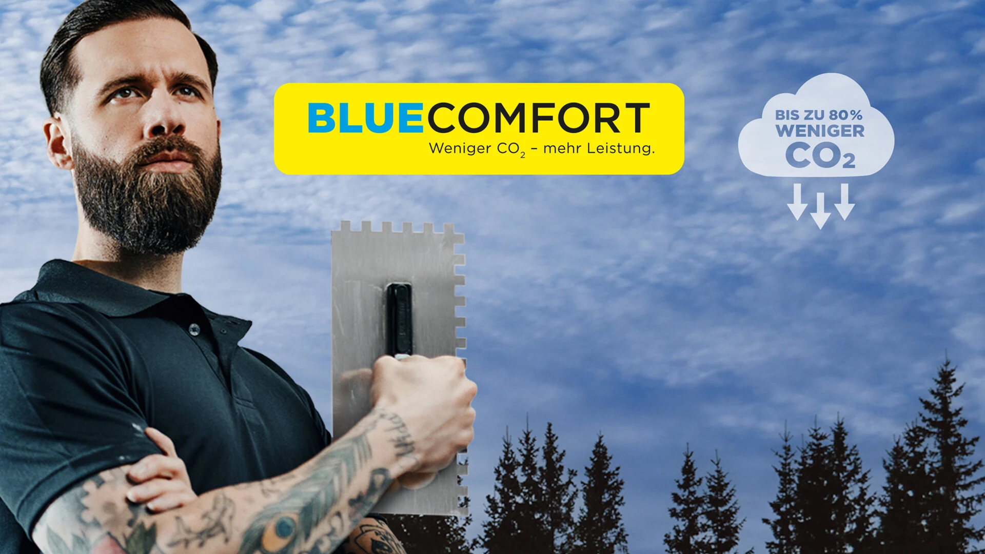 Handwerker mit Zahnkelle vor bewaldetem Hintergrund, daneben Werbebotschaft ‚BLUE COMFORT – Weniger CO₂, mehr Leistung‘ mit Hinweis auf bis zu 80 % CO₂-Reduktion
