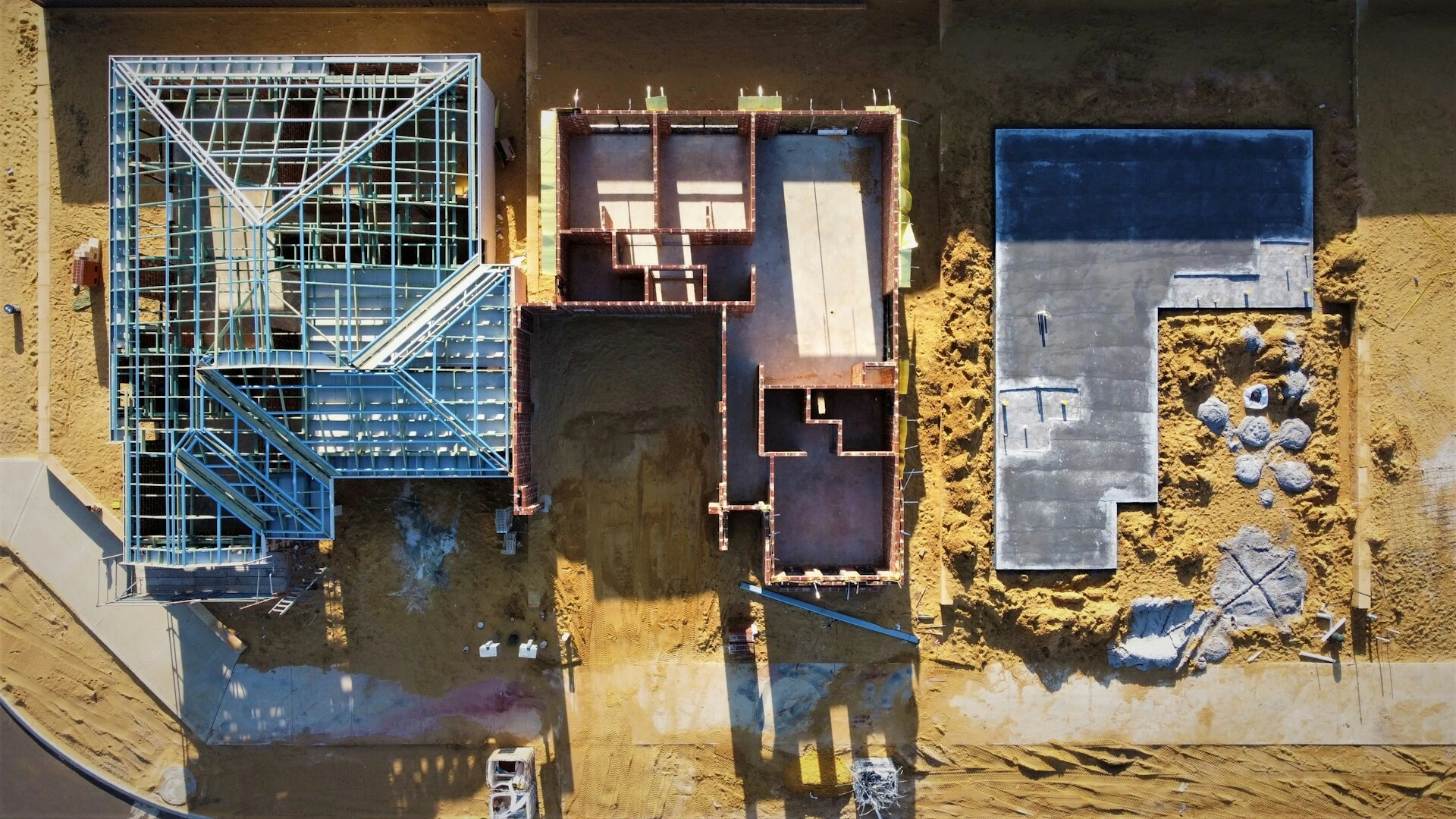 Luftaufnahme eines Rohbaus mit Fundamenten und Bauchemie‑relevanten Bauteilen im Neubau.