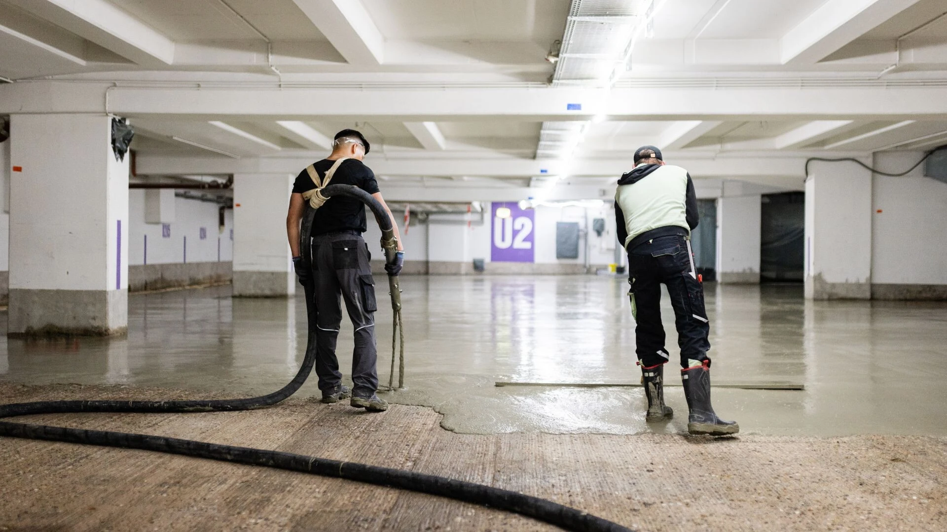 Einbau von Betonersatzmörtel im Parkhaus: Das Material wird maschinell eingebracht und anschließend gleichmäßig auf der Sanierungsfläche verteilt.