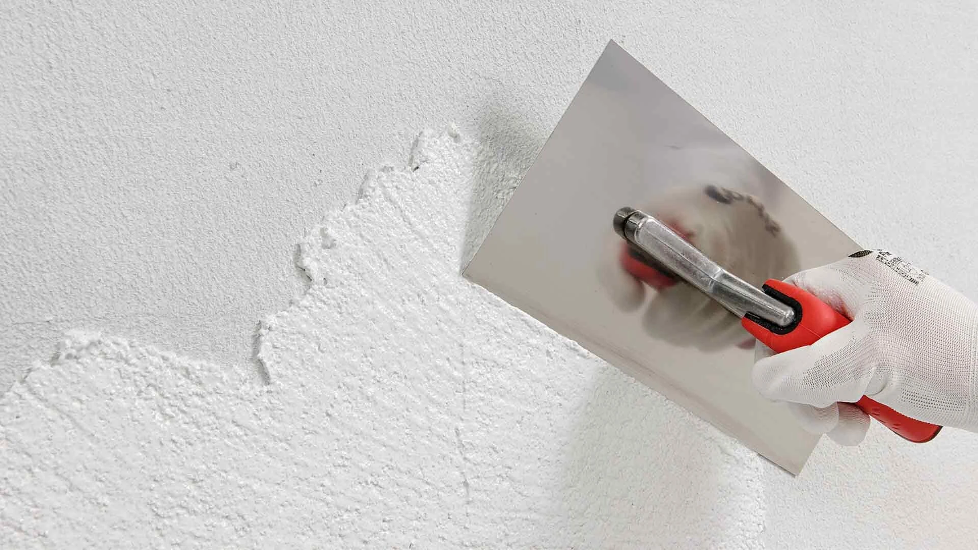Verarbeitung von Kalkputz mit einem Spachtel an einer Wand