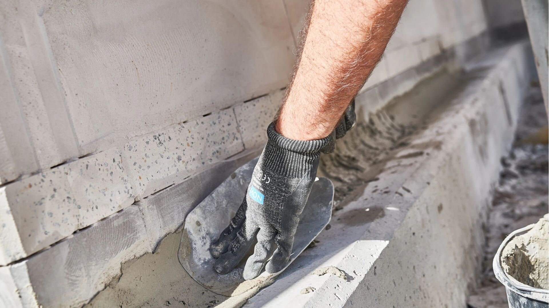 Fachhandwerker führt eine Hohlkehle als Anschlusspunkt von Boden zu Wand durch