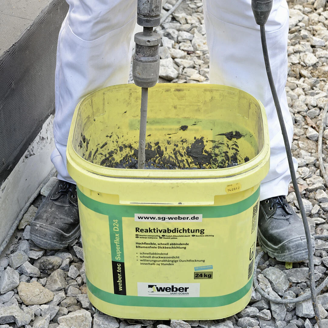 Fachhandwerker vermischt den weber.tec Superflex D 24 mit einem Rührgerät im Eimer des Produkts