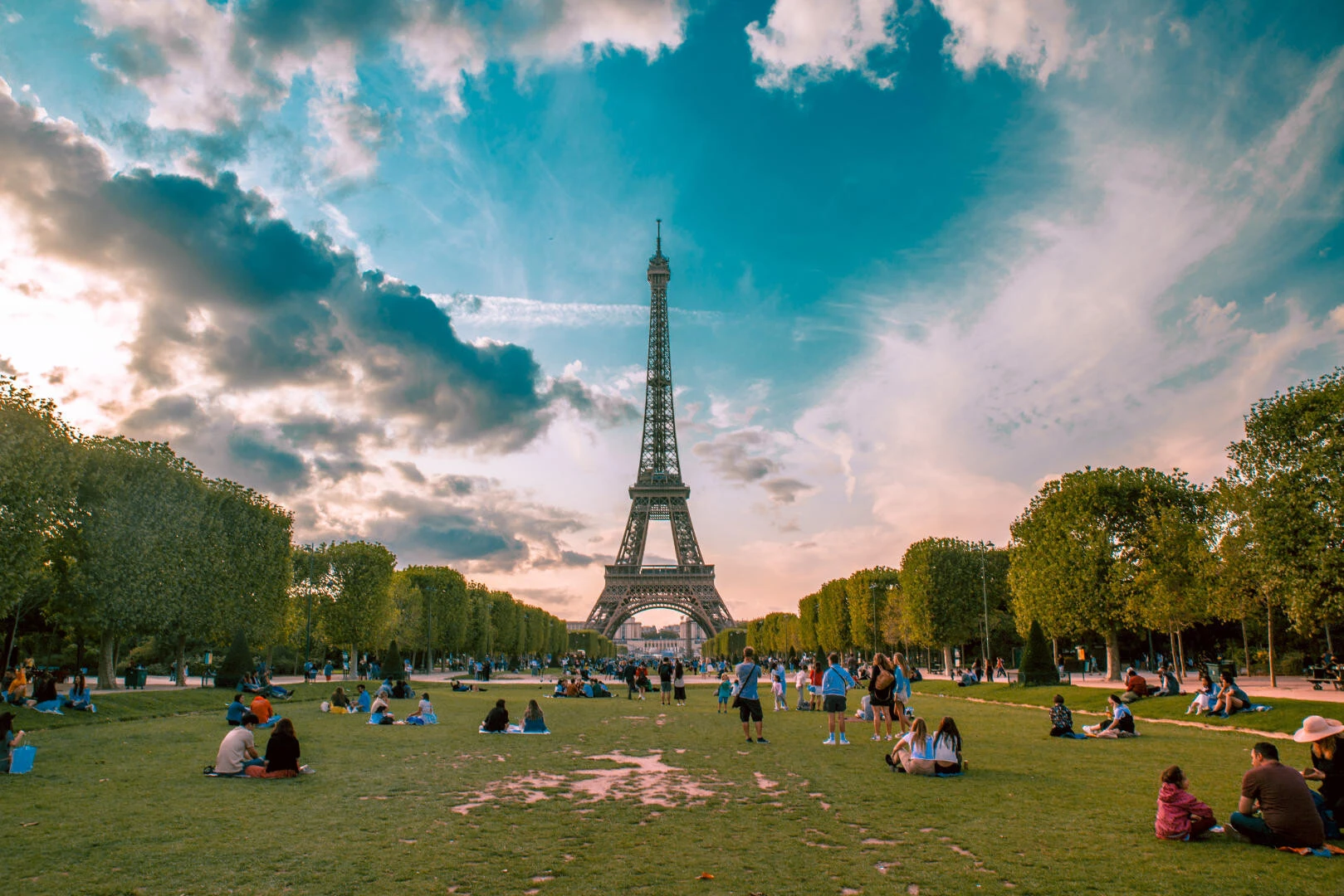 Eiffelturm in Paris bei Sonnenaufgang vor blauem Himmel mit Wise im Vordergrund