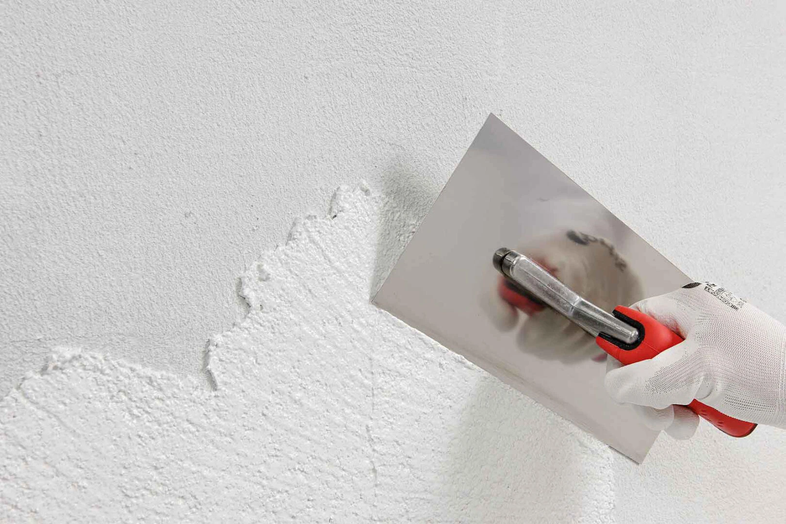 Putz wird mit einer Kelle an der Wand aufgetragen
