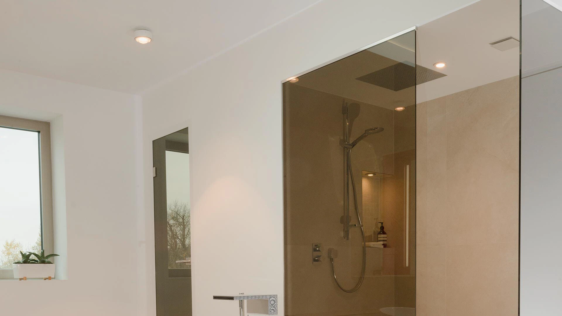Aufnahme eines Badezimmers, wo die Dusche mit Fliesen ausgekleidet ist und zeitgleich an Putz angrenzt