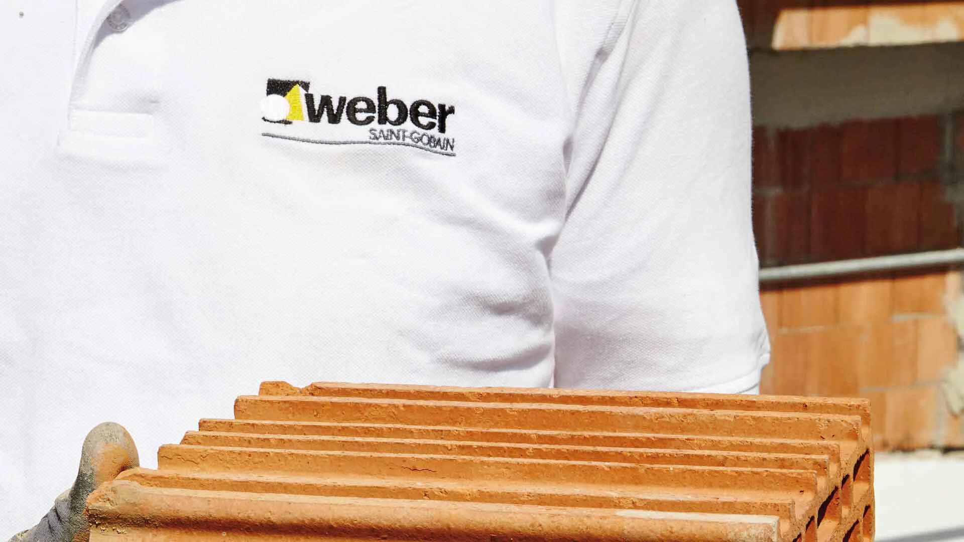 Weber Mitarbeiter präsentiert einen Hightech-Mauerstein