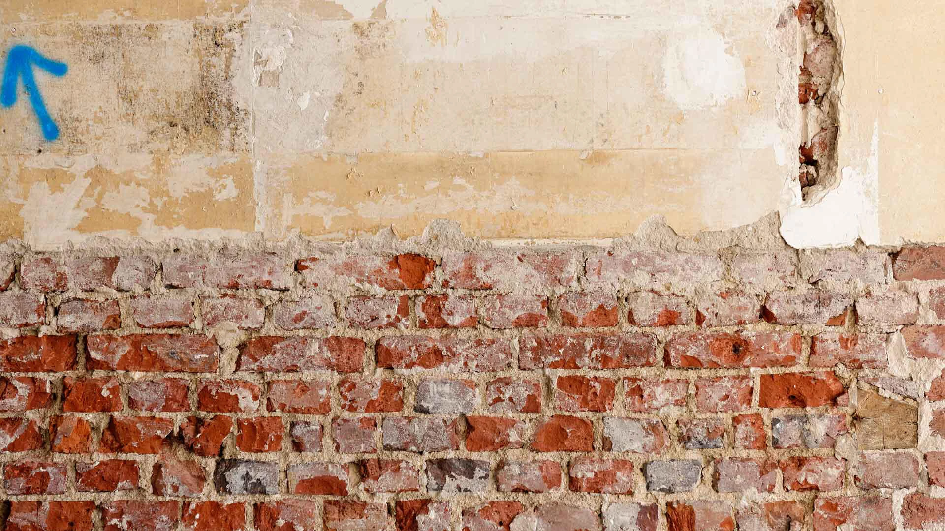 Wand vor Renovierung mit freigelegtem Mauerwerk