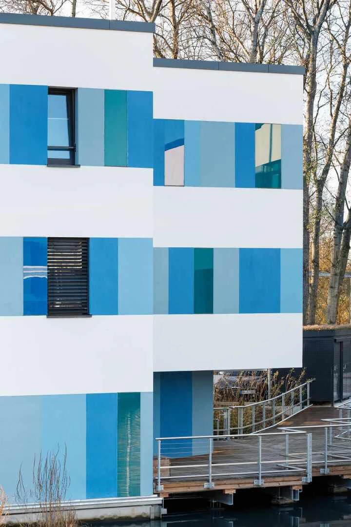 Fassade mit weber.therm style Elementen in verschiedenen Blautönen
