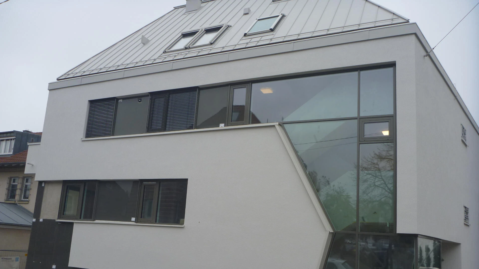Mischfassade eines Mehrfamilienhauses mit Putz, Glasplatten und Fensterelementen