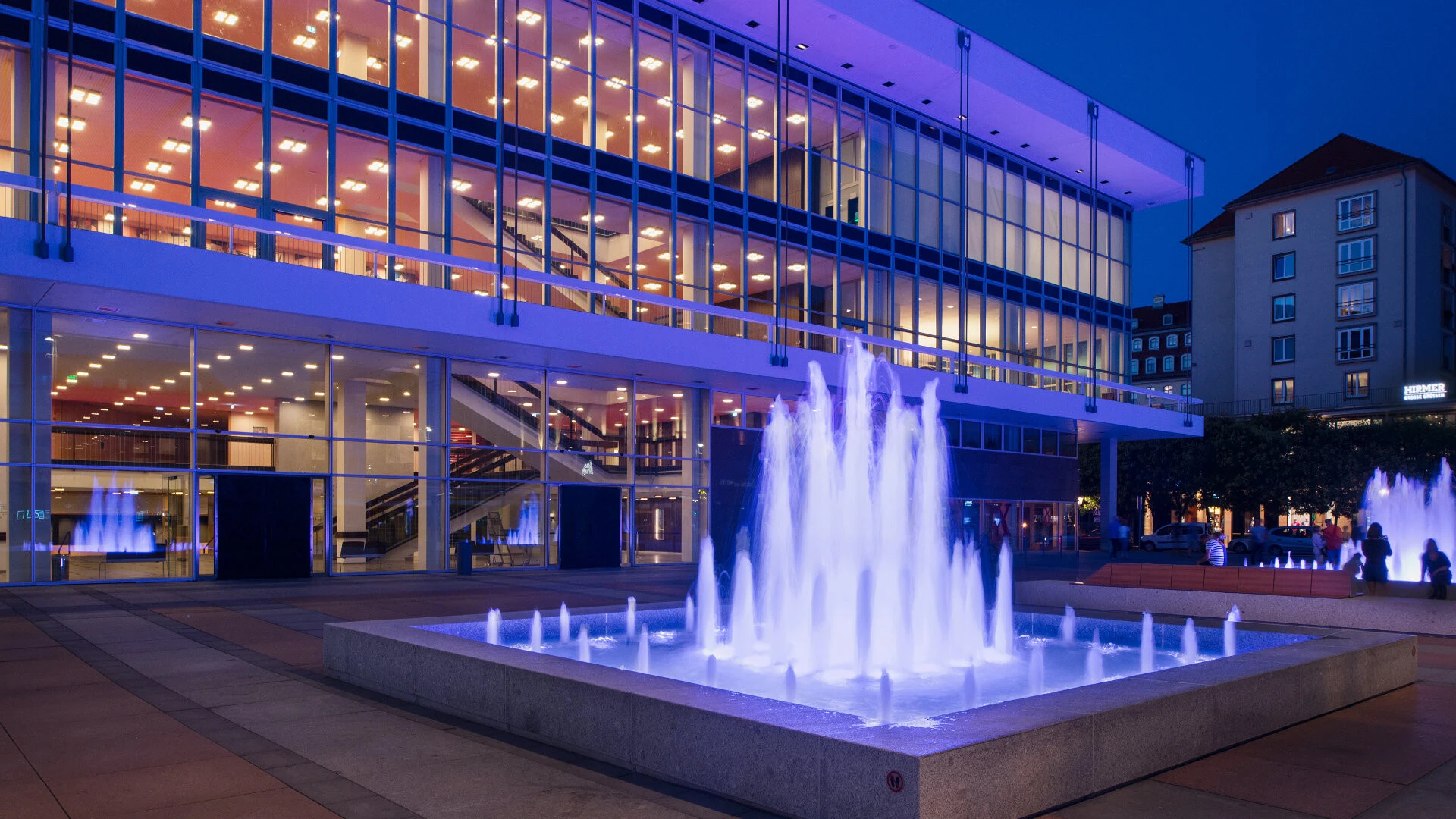 Beleuchteter Brunnen vor dem Kulturpalast Dresden bei Nacht 