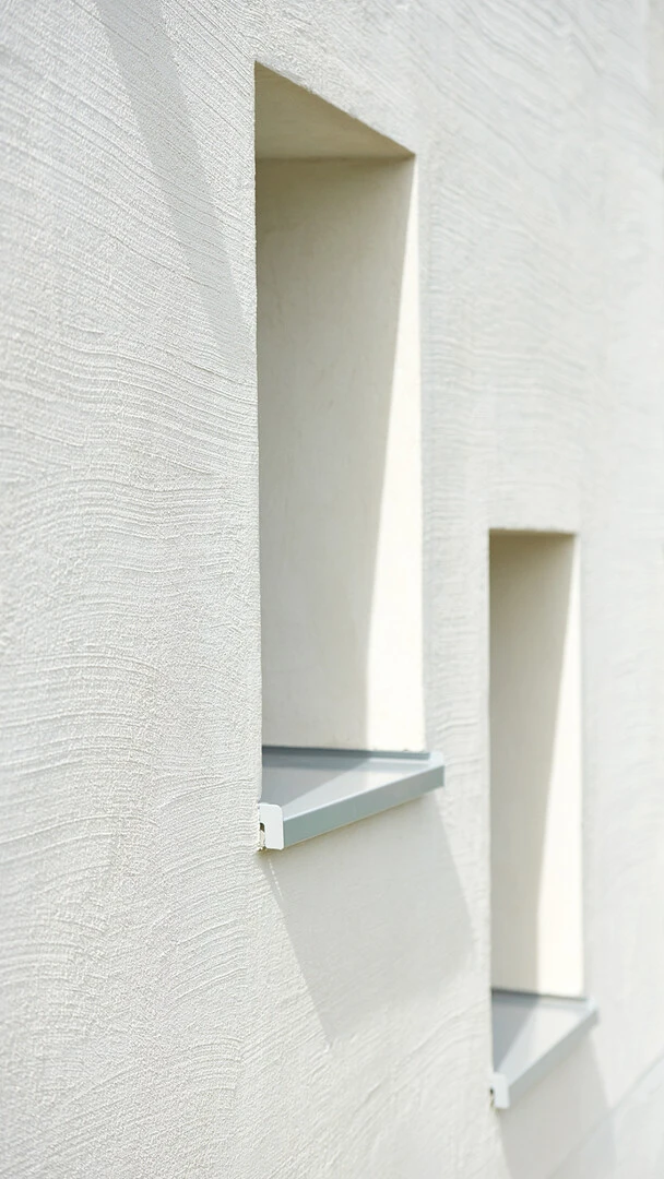 Nahaufnahme einer weißen Fassade mit Fenstern, die mit WDVS gedämmt ist