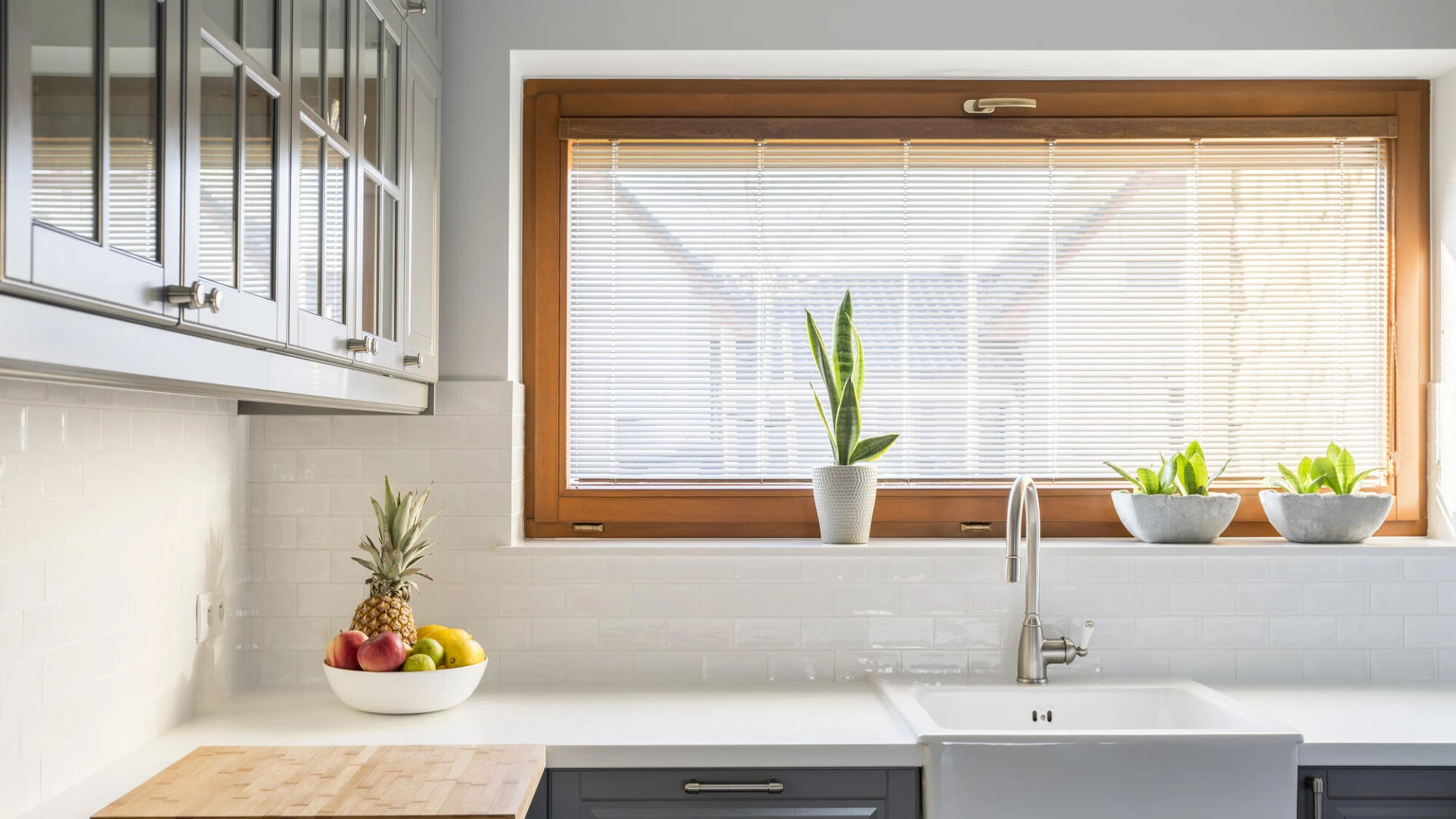 Detailaufnahme einer Küchenwand mit Fenster, Arbeitsplatte und Hängeschränken