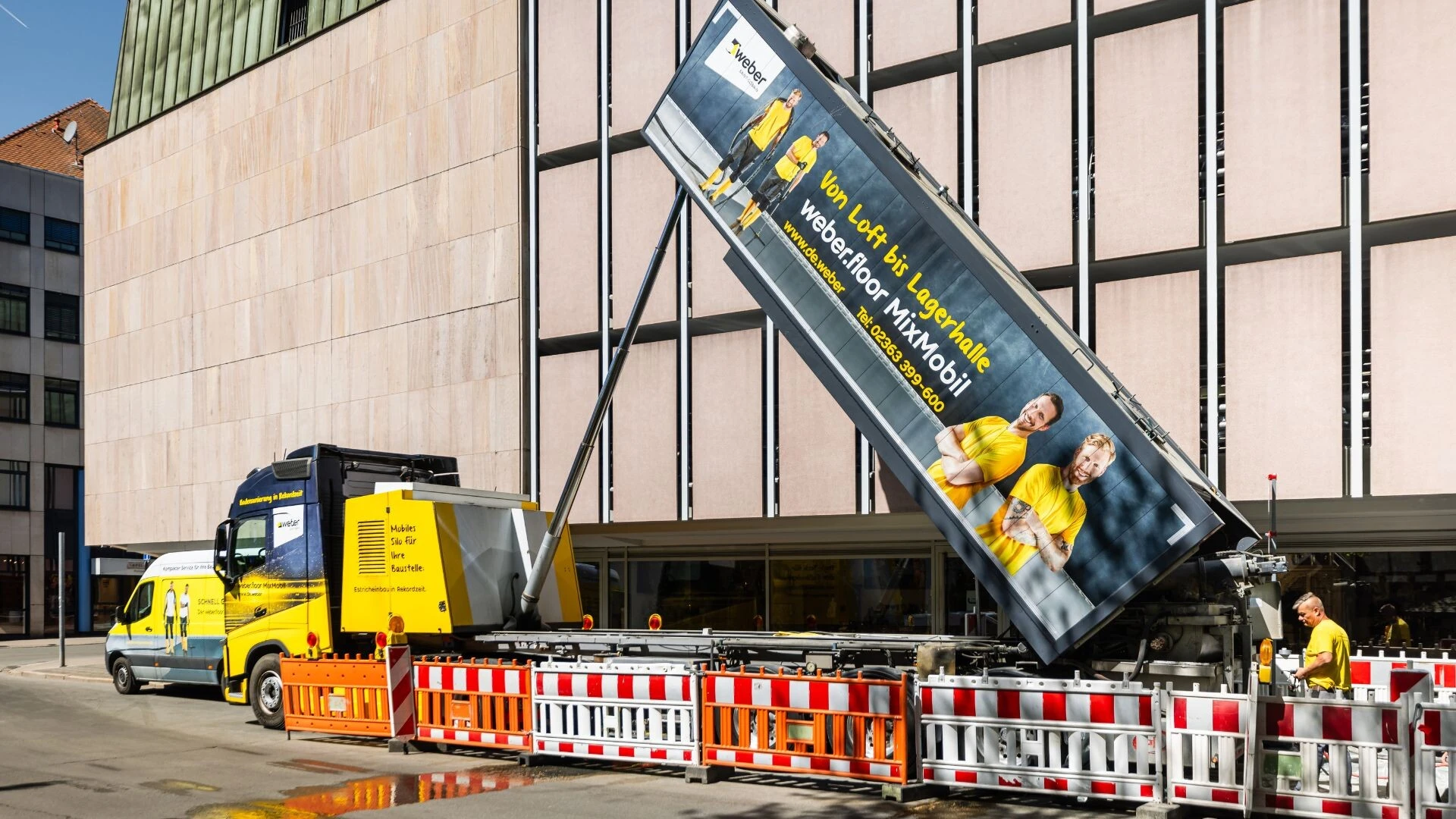 Weber MixMobil vor einem Parkhaus im Einsatz. Die mobile Mischanlage liefert Betonersatzmörtel direkt auf die Baustelle für die Parkhaussanierung.