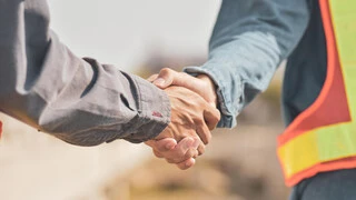 Zwei Arme, die sich die Hand reichen
