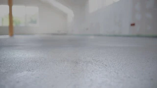 Nahaufnahme eines Estrichs in einem Rohbau, der Hintergrund ist sehr unscharf, der Fokzs liegt auf der Texture in der Mitte des Bildes