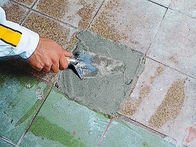 Fehlstelle im Estrich wird Mörtel ausgeglichen