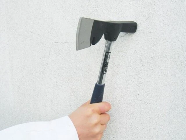 Abklopfen alter Putzfassaden mit einem Hammer, wenn man die Putzfassade sanieren möchte