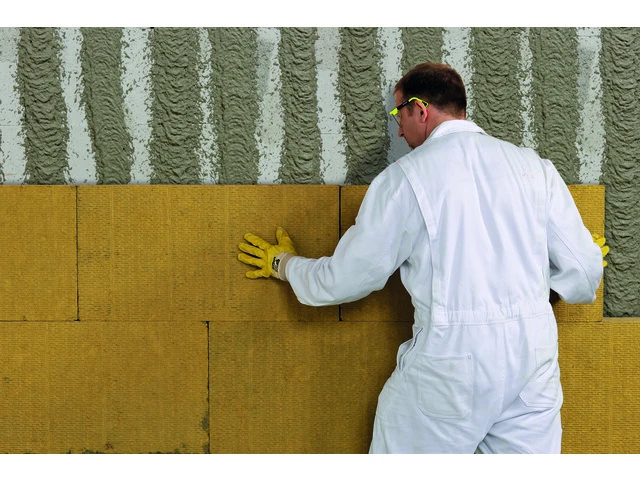 Rückwärtige Ansicht auf das Einbetten von weber.therm MW 035 express in den Klebemörtel an der Fassade