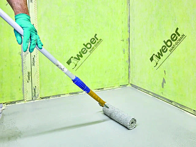 Rollkleber wird mit einer Lammfellrolle auf den Boden aufgetragen