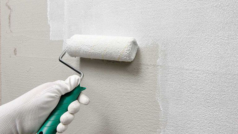Grundierung Fassade Grundieren einer Wand mit einer weißen Farbrolle