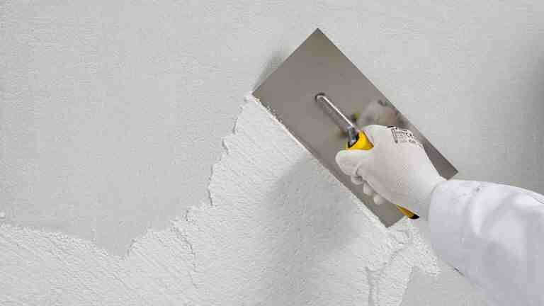 Pastöse Oberputze Verspachteln eines pastösen Oberputzes auf einer weißen Wand