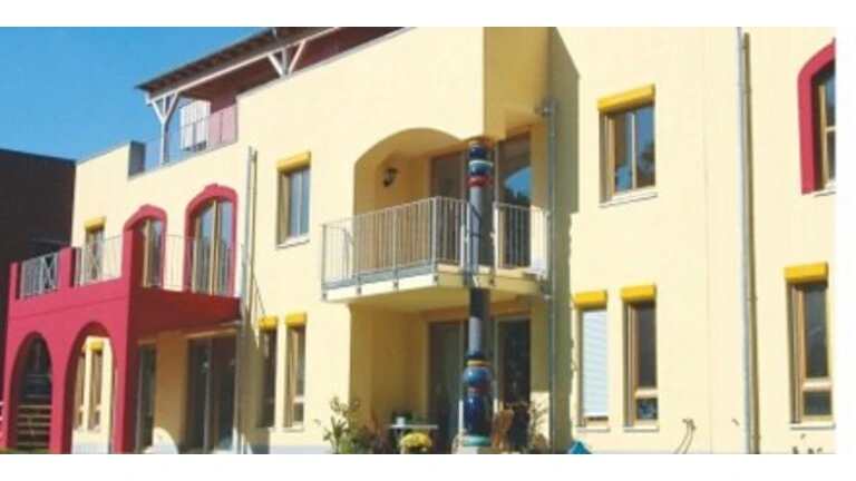 Aufnahme einer hellgelben Fassade eines Reihenhauses