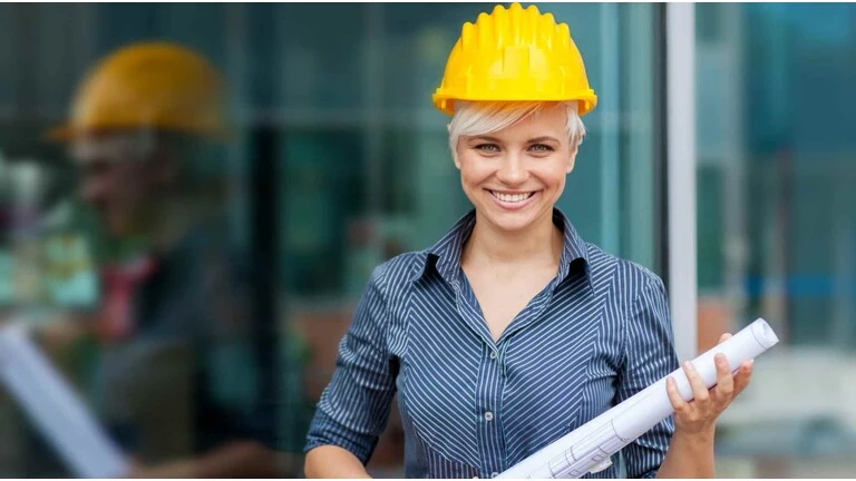 Architektin mit gelbem Helm und Papierrolle in der Hand