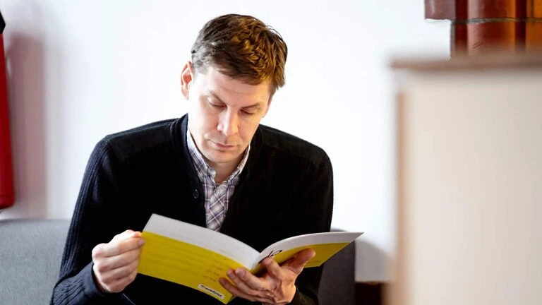 Mann mit do up Magazin in der Hand welches das Magazin von Weber für Architekten ist