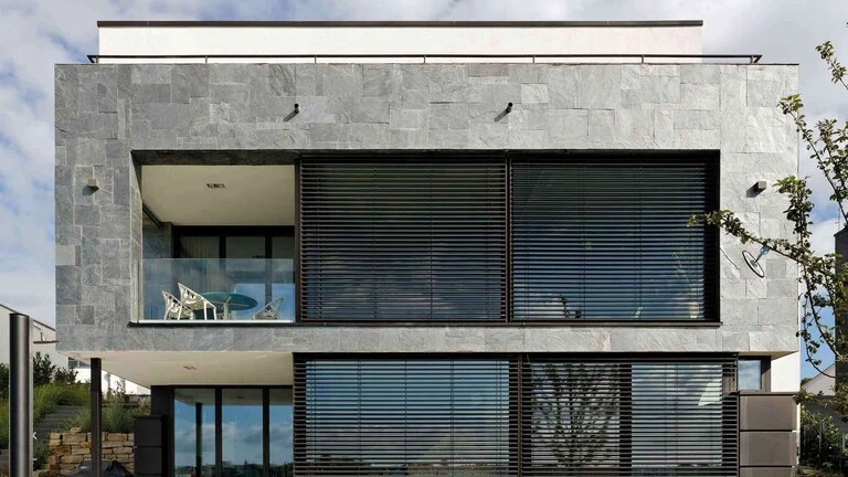 Hausfassade, die mit grauen Schieferplatten gestaltet wurde
