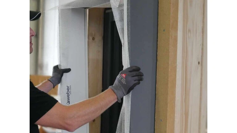 Handwerker setzt weber.projekt WDVS Fertigzarge auf Holzbau auf