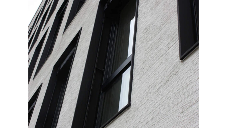 Nahaufnahme einer Fassade, in welche die Fenster mithilfe der Fertigzarge eingebaut wurden